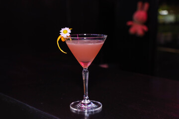 A delightful pink cocktail with flower garnish. This elegant drink is perfect for a special occasion, showcasing a fresh, fruity flavor profile
