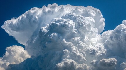 A close-up view of a towering cumulonimbus cloud against a brilliant blue sky