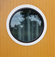 Round glass window with grey curtains