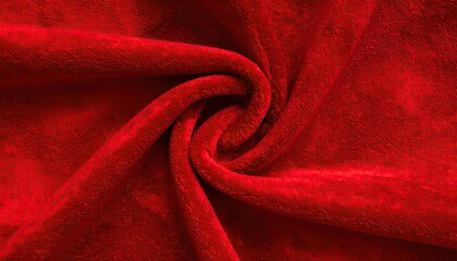 Abstract close-up of rich red plush fabric with swirling folds and soft texture.