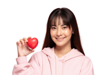 Asian Young Asian woman holding red heart stress ball smiling in pink hoodie conveying warmth and care, healthcare concept and positive emotion