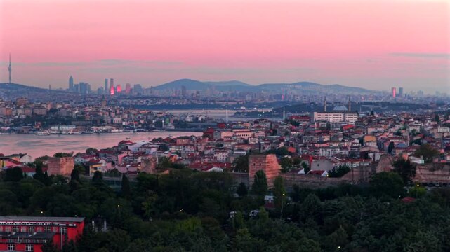Sunset golden hour pink purple sky afterglow clouds Istanbul Turkey T&uuml;rkiye aerial drone panoramic landscape cityscape Bosphorus Strait harbor view buildings city skyscrapers pan left slowly motion