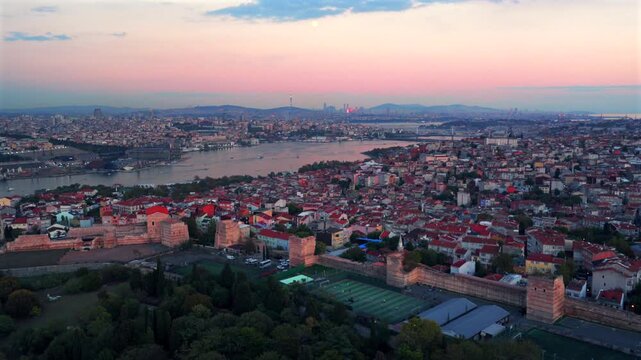 Istanbul Turkey T&uuml;rkiye aerial drone Bosphorus Strait ferry boats harbor view sunset golden hour pink sky afterglow cityscape buildings panoramic landscape skyscrapers mosque forward upwards