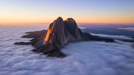 Dramatic Sunrise Over Mountain Peak Emerging from a Sea of Clouds