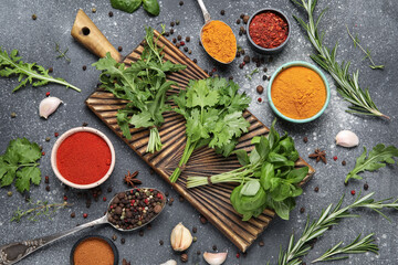 Different herbs and spices on black grunge background, closeup