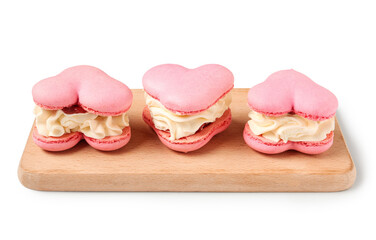 Wooden board with sweet heart-shaped macaroons on white background. Valentine's Day celebration