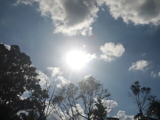 Bright sunburst in clear sky with dramatic clouds and radiant light.