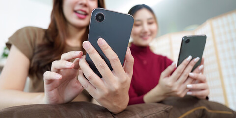 Social Connection. Two friends enjoying smartphone interaction and sharing moments.