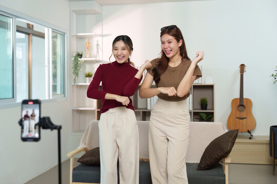 Social Media Fun. Two friends dancing and enjoying a moment together in a cozy living room. - Powered by Adobe