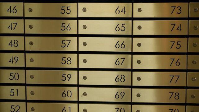 Orderly rows of brass safety deposit boxes inside a secure bank vault, with numbered panels and metallic sheen, highlighting security and confidential storage for valuables