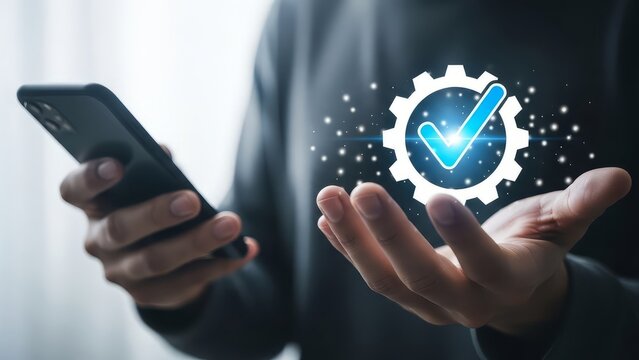 A person holding a phone and a gear with a checkmark inside floating above their open hand in the air