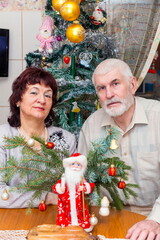 beautiful elderly couple holding big clock on new years eve