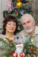 beautiful elderly couple holding big clock on new years eve