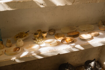 Still life composition showcasing translucent alabaster tableware and grape decorations
