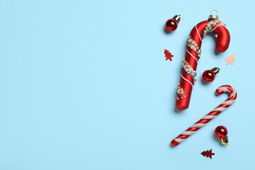 Red Christmas balls and candy canes on blue background