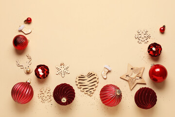 Red Christmas balls and wooden decorations on beige background
