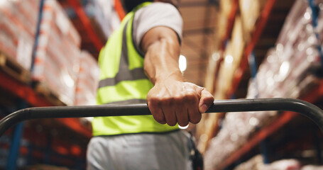 Hand, logistics and trolley with man in warehouse aisle for delivery, distribution or shipping....