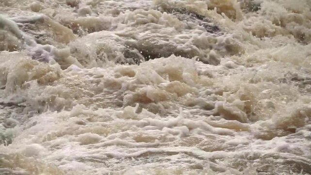 Cip of swirling, fast-flowing murky water. Splashing patterns convey a sense of urgency and natural power, suitable for scenes involving flooding, heavy rain, or wild river environments.