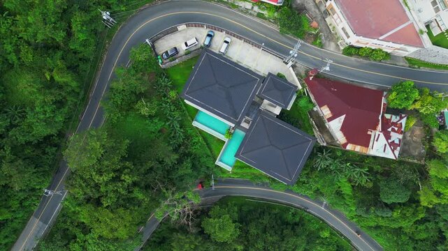 A rotating top-view aerial of Hōm Amara&rsquo;s modern hillside layout with turquoise pool and forest surrounds in Tagaytay, Cavite, Philippines