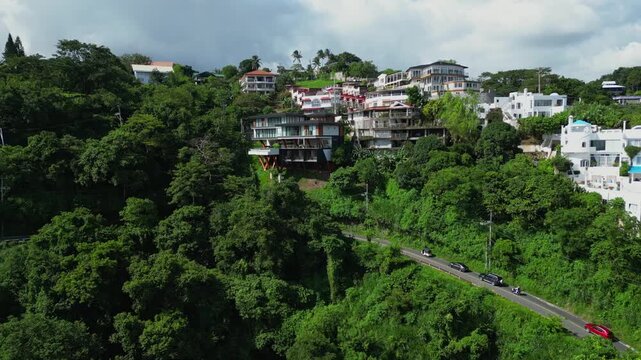 A push-out aerial of hillside hotels along Ligaya drive surrounded by tropical trees and winding roads in Talisay, Batangas, Philippines
