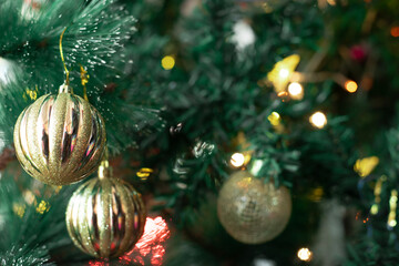 Golden Christmas Ornaments on Illuminated Green Tree