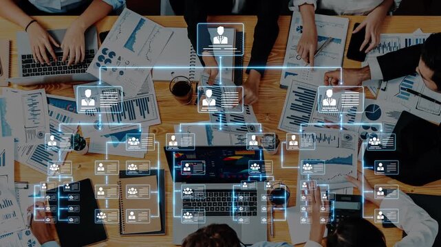 A diverse team engages in a strategic business meeting, surrounded by charts and laptops, showcasing remote collaboration and data analysis in a modern office setting. Raster - Powered by Adobe