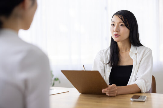 Woman Taking Notes During a Conversation at Work