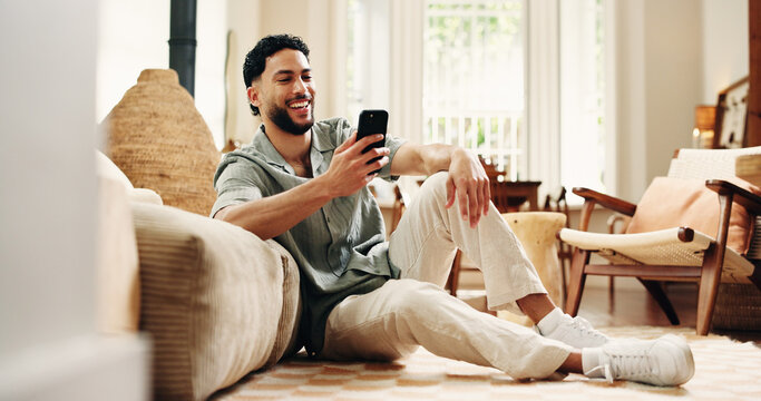 Man, laugh and scroll with phone in home for funny social media video, online dating and virtual chat. Happy, person and browsing in house with tech for text message, internet humor and mobile app.
