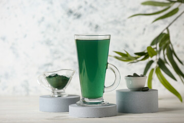 Glass of fresh spirulina drink on white wooden table, closeup