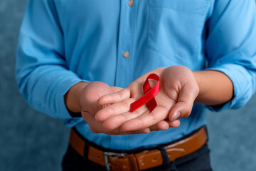 Man holding red ribbon for World AIDS Day awareness