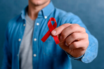 Person showing red awareness ribbon for World AIDS Day