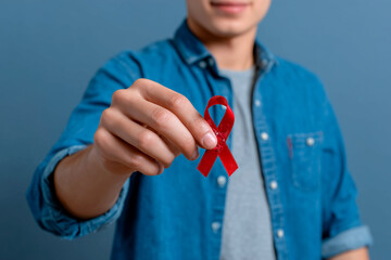 Man holding red ribbon advocating for World AIDS Day