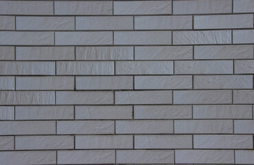 Textured white brick wall featuring a modern design with varying surface patterns, creating a visually appealing backdrop for architectural or interior design projects