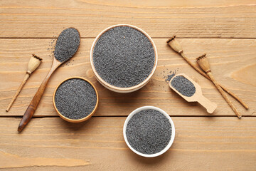 Composition with bowls of poppy seeds on wooden background
