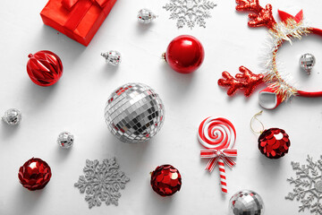 Composition with disco balls, gift box and Christmas decor on light pink background