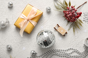 Composition with disco balls, gift box and Christmas decor on white grunge background