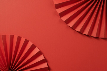 Abstract vibrant red background with elegant folded paper fan patterns, ideal for festive greetings, cultural events, and stylish graphic design concepts