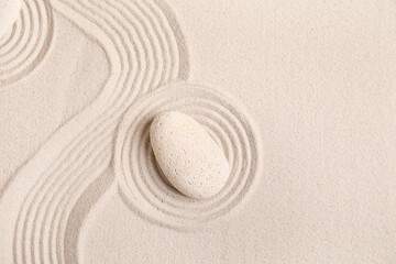 Composition with spa stone and lines on sand as background, closeup. Zen concept
