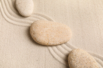 Composition with spa stones and lines on sand as background, closeup. Zen concept