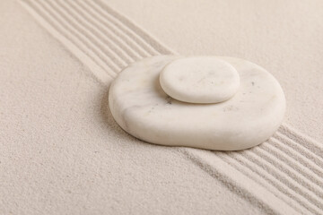 Composition with spa stones and lines on sand as background, closeup. Zen concept