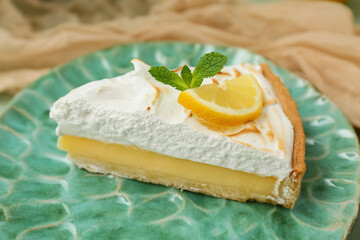 Tasty lemon pie on green plate as background, closeup