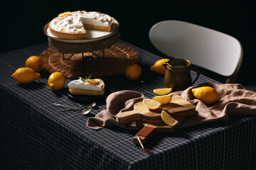 Plate with piece of tasty lemon pie and ingredients on table