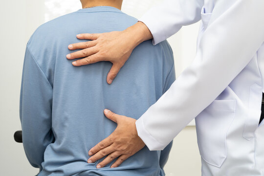 Physical therapy, Asian therapist doctor treat perform pain young man in hospital. - Powered by Adobe