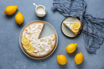 Naklejka premium Plate with tasty lemon pie and jug of milk on blue grunge background