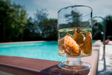 Vaso di vetro con fichi d'india a bordo piscina