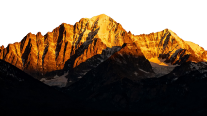 Golden-lit mountain peaks at sunrise with rugged ridges and shadows