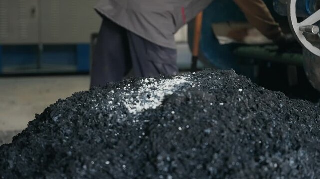 Large pile of processed crumb rubber inside an industrial recycling facility