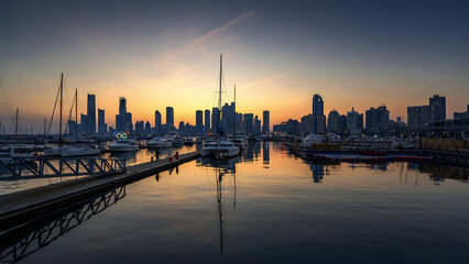 Fototapeta premium Sailboats and City Skyline at Sunset in Marina Harbor