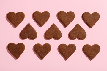 Sweet chocolate heart-shaped cookies on pink background. Valentine's Day celebration