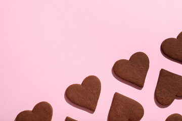 Sweet chocolate heart-shaped cookies on pink background. Valentine's Day celebration